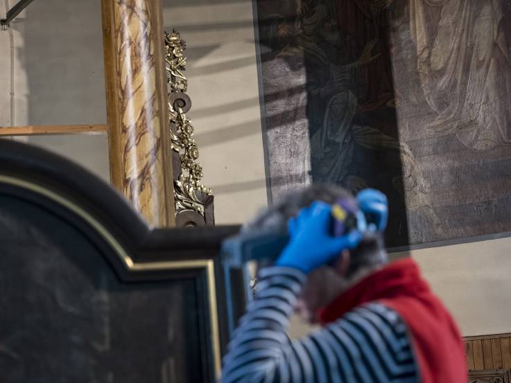 Muriel Prieur munie de ses utensils de travail pour inspecter un tableau