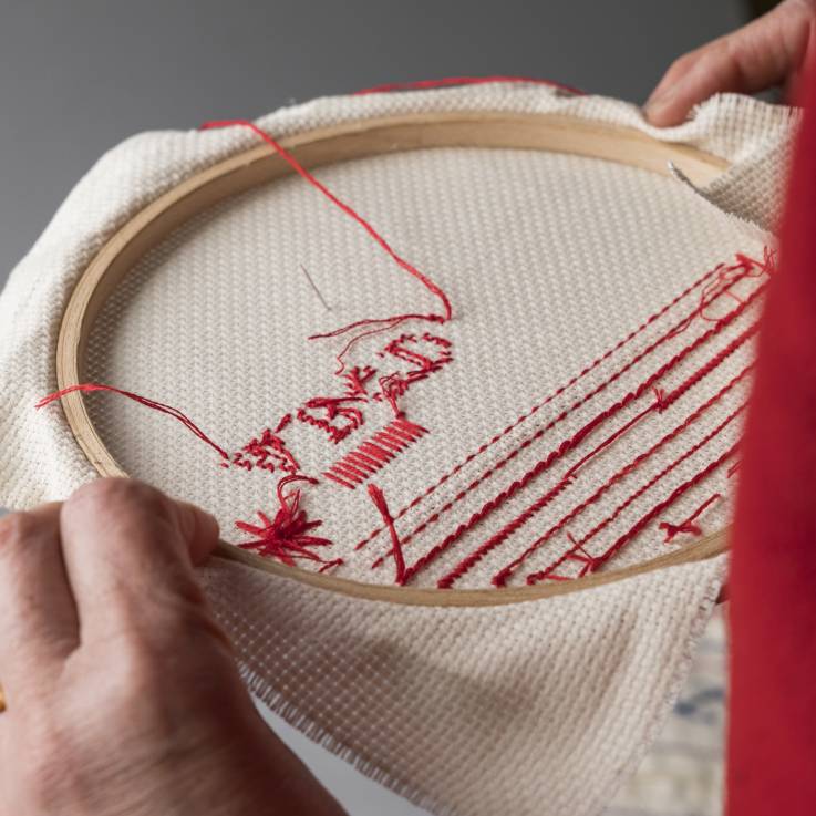 Die Rückseite eines runden Mustertuchs wo rote Fäden sichtbar sind