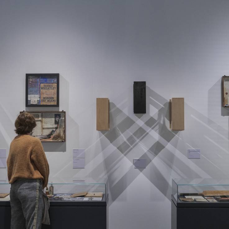 Une femme regarde un objet dans une exposition